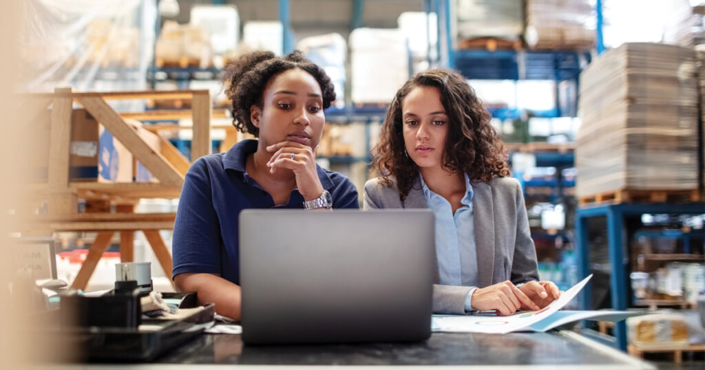 women supply chain collaborating working in warehouse with laptop