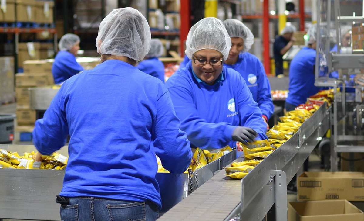 Packing line crew assembling customer products at a contract packaging plant
