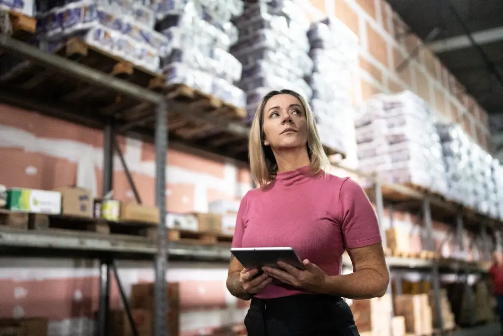 Mujer empaquetando comprimidos en un almacén de co-pack